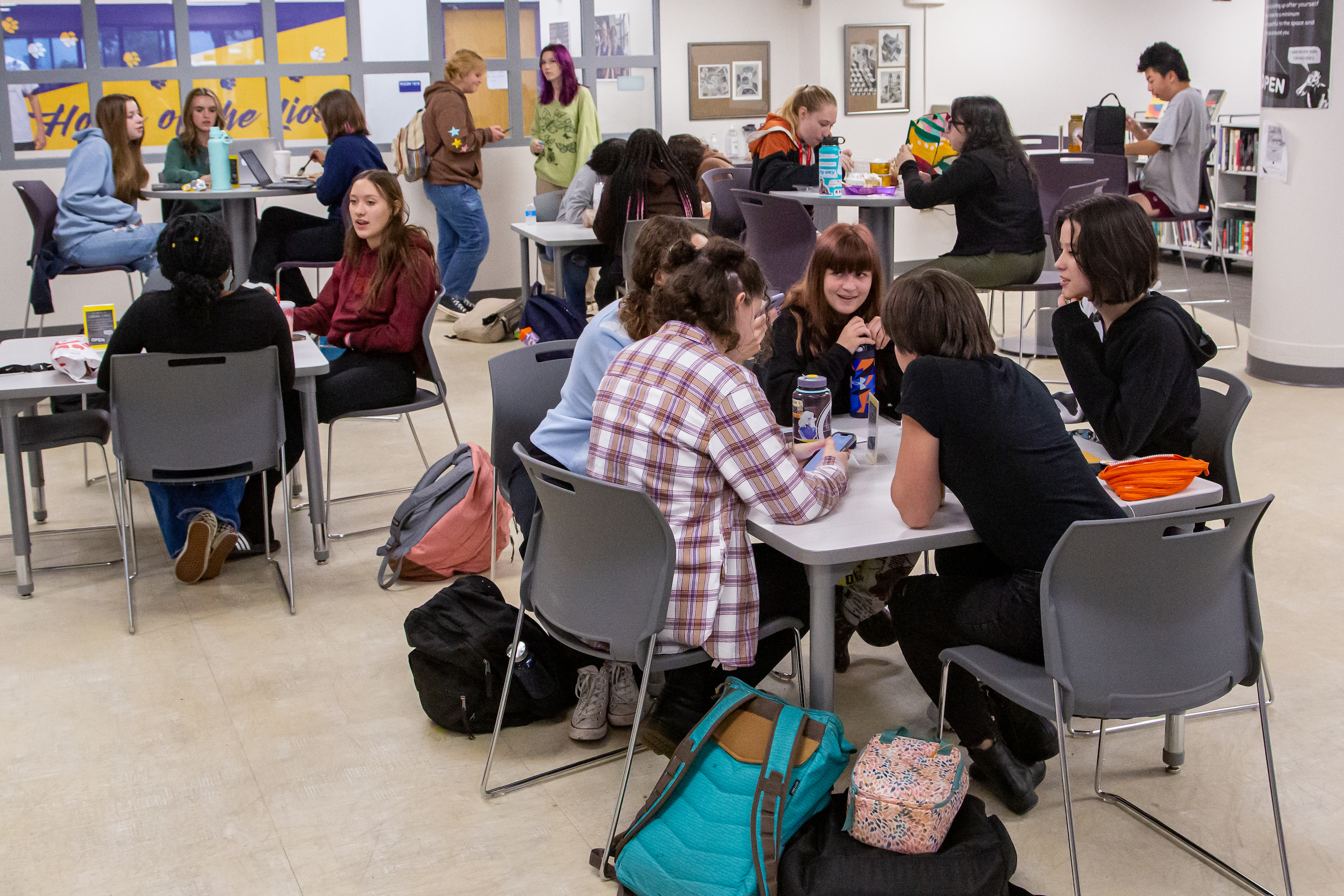 Groups of students gathered in a library common area between classes