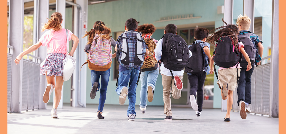Image of children running towards school doors