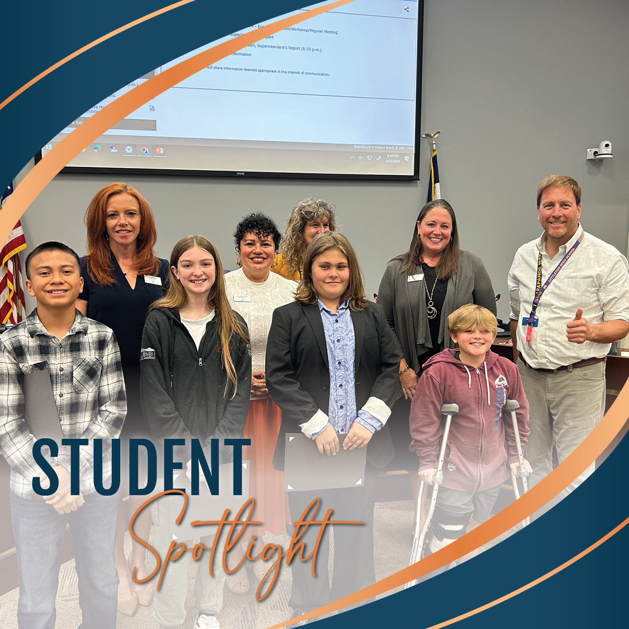 Group photo of Centennial Academy students with their Student Spotlight certificates and the Board of Education in front of the Board's dais.