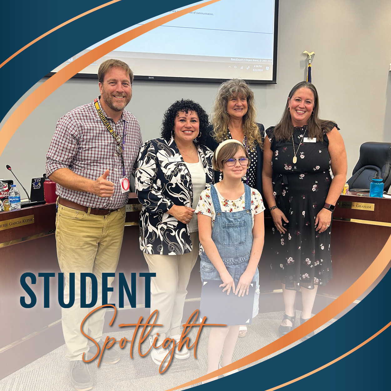 Annie L. holds her Student Spotlight Certificate and is surrounded by the LPS Board of Education in the Boardroom.