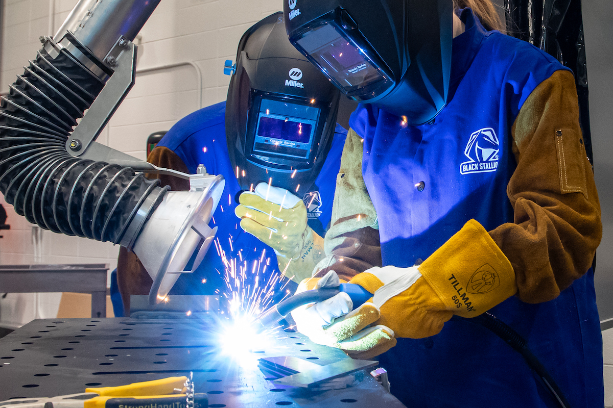 Two students are working on a welding project.