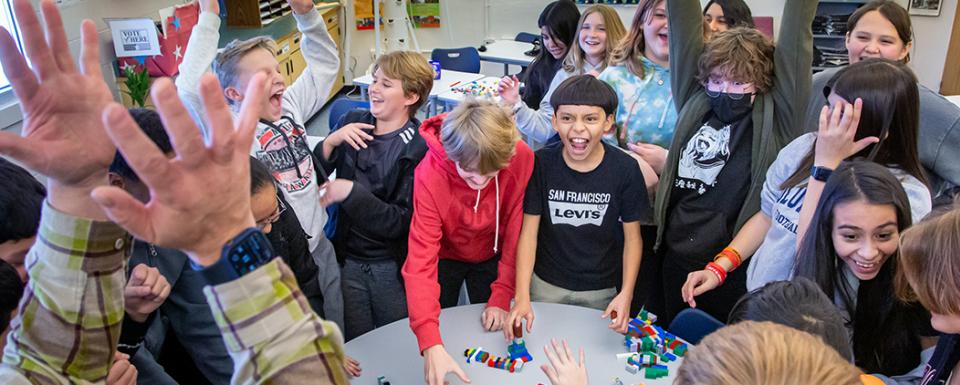 middle school students happy building Lego blocks